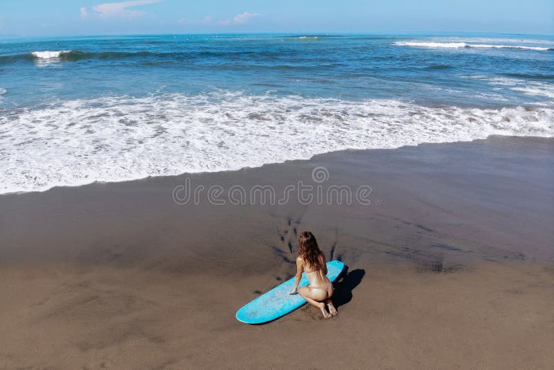 Vackra sporter med sexig bikini sitter på surfbräde på stranden innan de surfar Modern aktiv idrott arkivfoton Vackra sporter med sexig bikini sitter på surfbräde på stranden innan de surfar Modern aktiv idrott arkivfoton