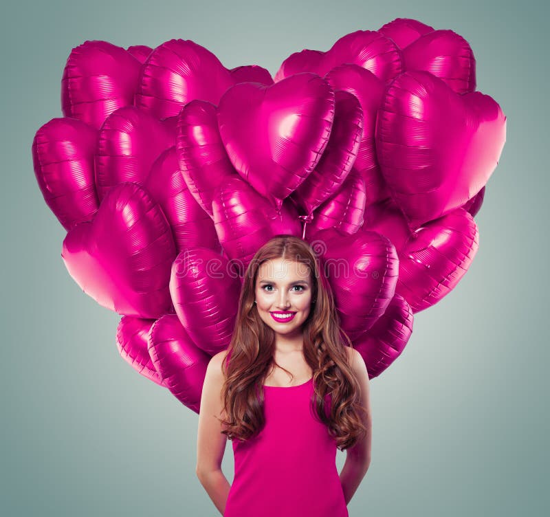 Vackra unga kvinnor med stort hjärta tillverkade av rosa ballonger i grå banderollbakgrund royaltyfria bilder Vackra unga kvinnor med stort hjärta tillverkade av rosa ballonger i grå banderollbakgrund royaltyfria bilder