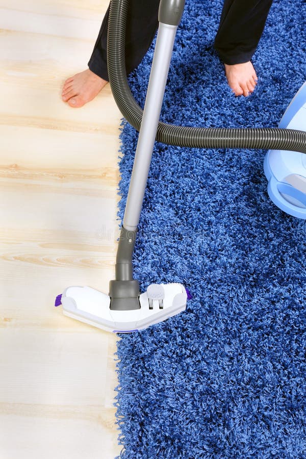 Vacuum Cleaner in Actionmen Cleaner a Carpet. Stock Photo Image of