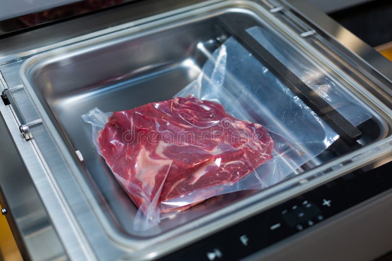 Vacuum Cleaner and Vacuum Packaging of Meat Products Stock Photo