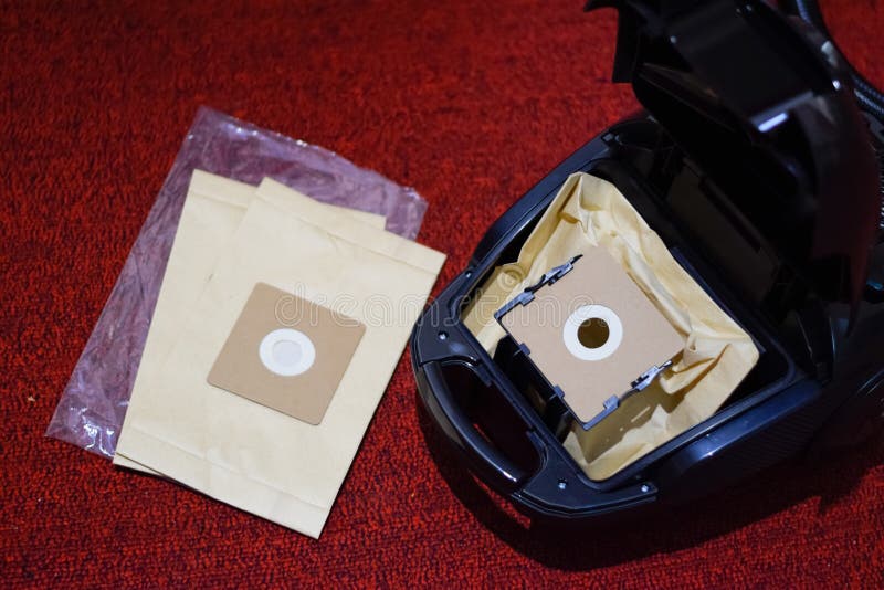 A Vacuum Cleaner with Set of Brushes and Bags. a Vacuum Cleaner on the Red Carpet Stock Photo