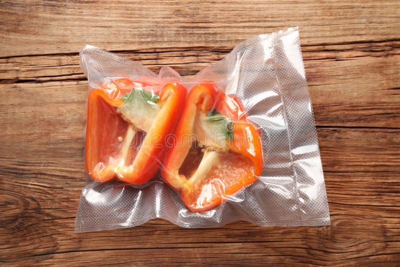 Vacuum Pack of Bell Pepper on Wooden Table, Top View Stock Photo