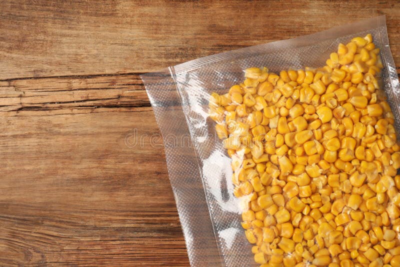Vacuum Pack of Corn on Wooden Table, Top View. Space for Text Stock