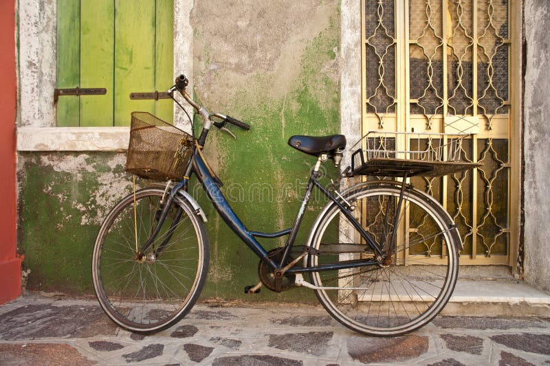 Vada in bicicletta la tendenza contro la parete variopinta, Burano, Italia fotografie stock Vada in bicicletta la tendenza contro la parete variopinta, Burano, Italia fotografie stock