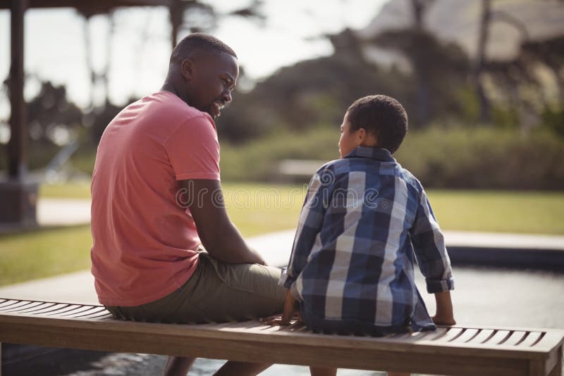 Smiling father talking to son near pool side. Smiling father talking to son near pool side