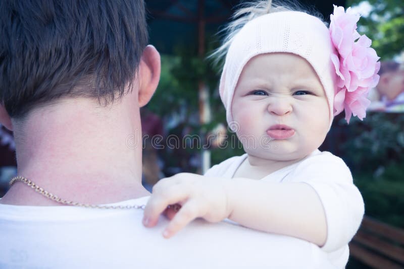 Vader Die Zijn Leuke Kleine Baby Omhelzen De Vader Kijkt Weg, Kijkt De Baby Met Grappig Gezicht