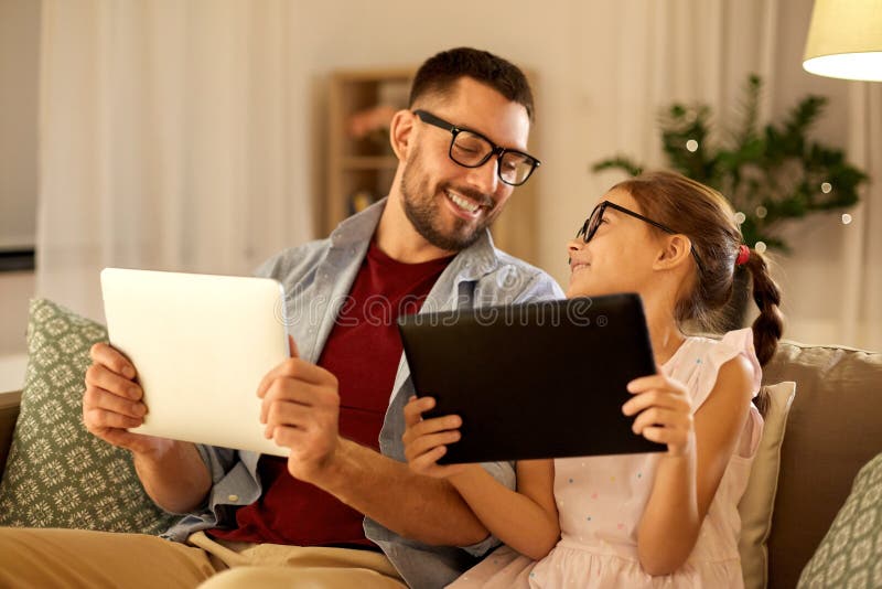 Vader en dochter met tabletcomputers thuis