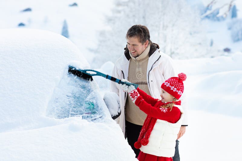 Vader en kind die van auto in de winter borstelen royalty-vrije stock afbeelding Vader en kind die van auto in de winter borstelen royalty-vrije stock afbeelding