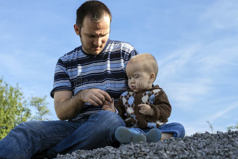 Vader en zoon zitten samen in de natuur stock afbeeldingen