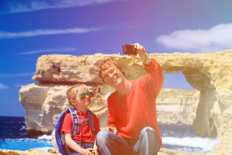 Vader en zoon die selfie tegen Azure Window maken stock fotografie Vader en zoon die selfie tegen Azure Window maken stock fotografie