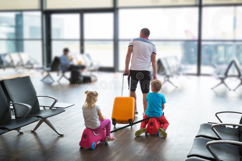 Vader met twee kinderen in de terminal vliegt samen op vakantie royalty-vrije stock foto's Vader met twee kinderen in de terminal vliegt samen op vakantie royalty-vrije stock foto's