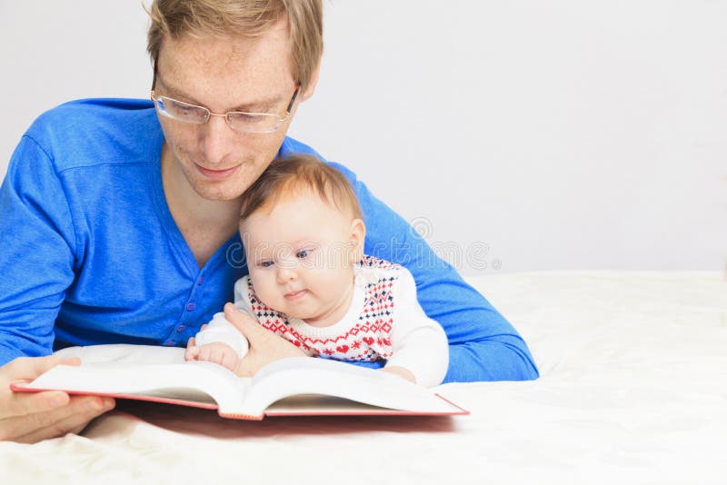 Vader met weinig dochterlezing thuis stock fotografie Vader met weinig dochterlezing thuis stock fotografie