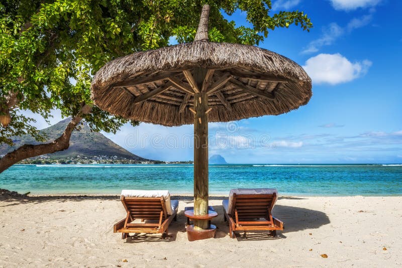 Vadios e guarda-chuva na praia tropical em Maurícias foto de stock Vadios e guarda-chuva na praia tropical em Maurícias foto de stock