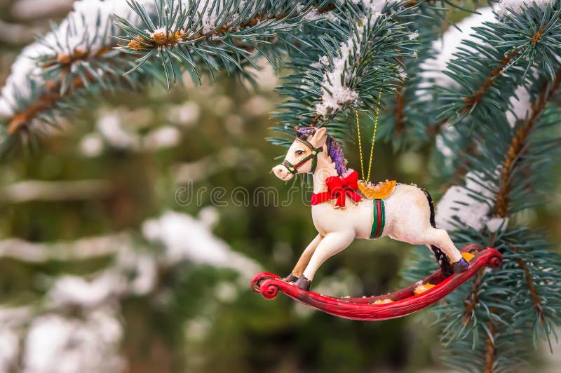 Vagga hästen och snöig sörja trädet som dekoreras för jul royaltyfri foto Vagga hästen och snöig sörja trädet som dekoreras för jul royaltyfri foto