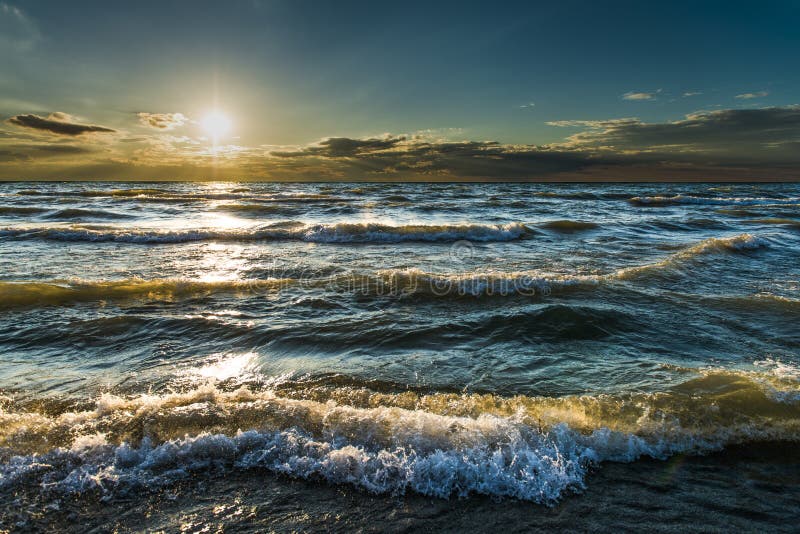 Vagues, beau coucher du soleil, lumière du soleil d'or par l'eau bleue de turquoise images libres de droits Vagues, beau coucher du soleil, lumière du soleil d'or par l'eau bleue de turquoise images libres de droits