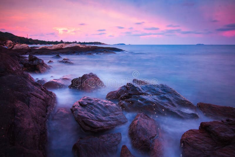 Vagues de roches et le beau coucher du soleil image stock