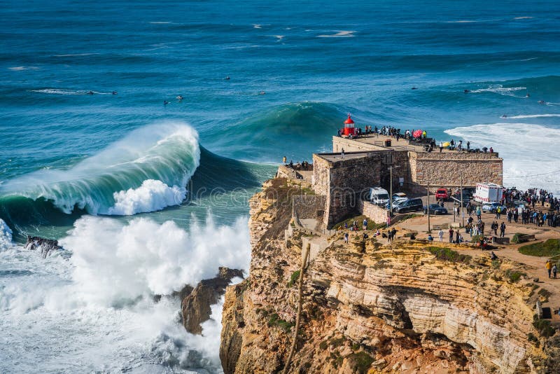 Giant waves crashing near the Fort of Sao Miguel Arcanjo Lighthouse in Nazare, Portugal. Nazare is famously known to surfers for having the biggest waves in the world. Giant waves crashing near the Fort of Sao Miguel Arcanjo Lighthouse in Nazare, Portugal. Nazare is famously known to surfers for having the biggest waves in the world.