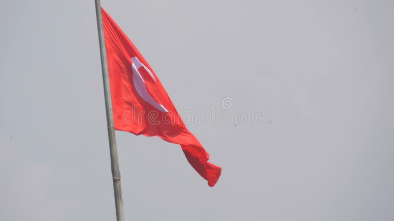 Vagues turques de drapeau national dans le vent contre le ciel