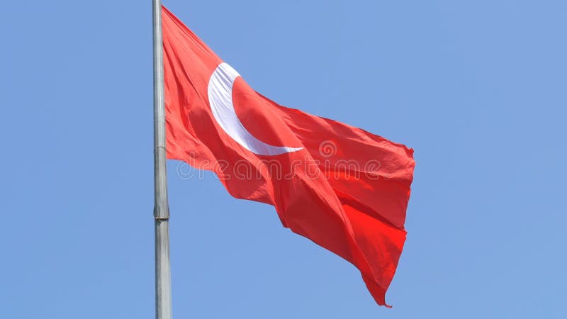 Vagues turques de drapeau national dans le vent contre le ciel