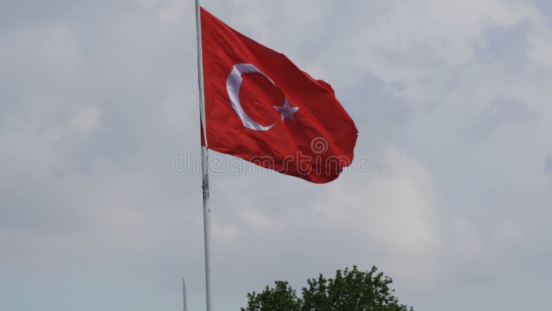 Vagues turques de drapeau national dans le vent contre le ciel