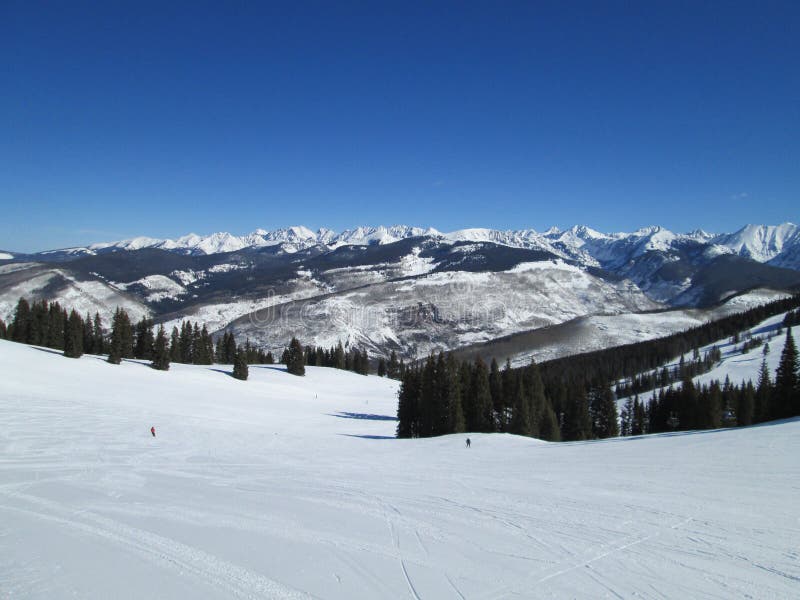 Vail Mountain Ski Path In Winter. Vail mountain ski path in the winter on a blue sky day with mountains in the background stock images Vail Mountain Ski Path In Winter. Vail mountain ski path in the winter on a blue sky day with mountains in the background stock images