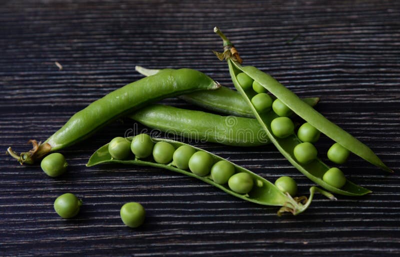 Vaina de guisante verde fresca con las habas aisladas en fondo de madera oscuro Vainas frescas de la composición horizontal de lo imágenes de archivo libres de regalías Vaina de guisante verde fresca con las habas aisladas en fondo de madera oscuro Vainas frescas de la composición horizontal de lo imágenes de archivo libres de regalías