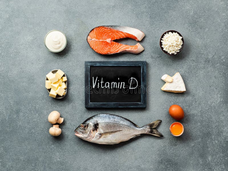 Vaitamin D sources concept. Fish, salmon, dairy products, eggs, mushrooms and chalkboard with Vitamin D words on gray stone background. Top view or flat lay. Vaitamin D sources concept. Fish, salmon, dairy products, eggs, mushrooms and chalkboard with Vitamin D words on gray stone background. Top view or flat lay.