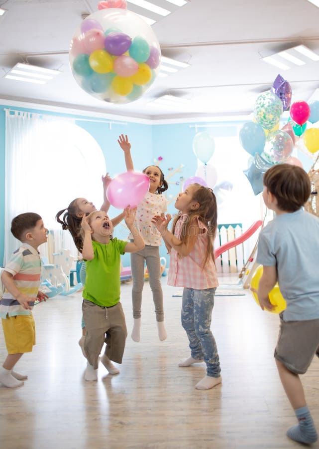 Vakantie, kinderjaren en vieringsconcept - verscheidene jonge geitjes die pret hebben en op verjaardagspartij springen in vermaak royalty-vrije stock afbeeldingen Vakantie, kinderjaren en vieringsconcept - verscheidene jonge geitjes die pret hebben en op verjaardagspartij springen in vermaak royalty-vrije stock afbeeldingen