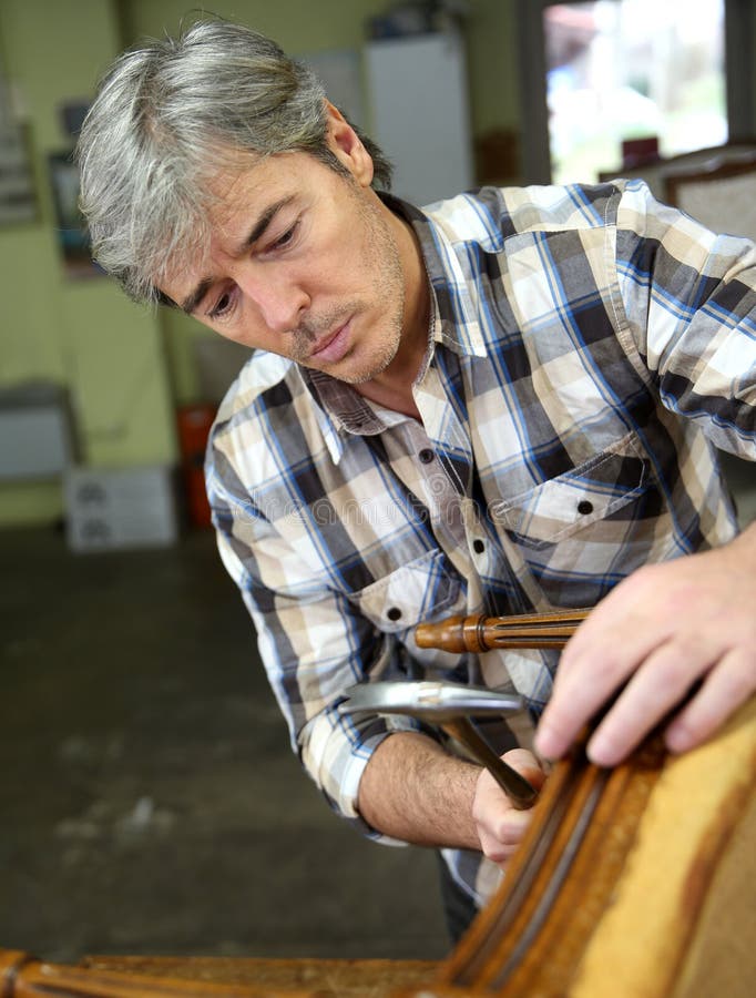 Vakman die houten leunstoel herstellen stock fotografie Vakman die houten leunstoel herstellen stock fotografie