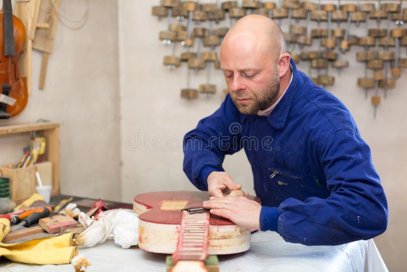 Vakman die onvolledige gitaar houden royalty-vrije stock foto Vakman die onvolledige gitaar houden royalty-vrije stock foto
