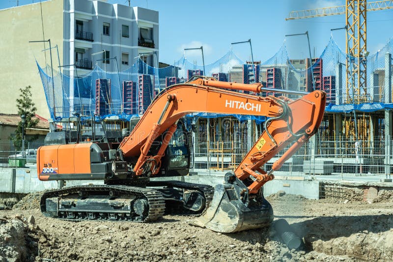 Valencia, Spagna - 30 marzo 2019: Hitachi backhoe lavora alla costruzione delle fondamenta di un edificio immagine stock libera da diritti Valencia, Spagna - 30 marzo 2019: Hitachi backhoe lavora alla costruzione delle fondamenta di un edificio immagine stock libera da diritti