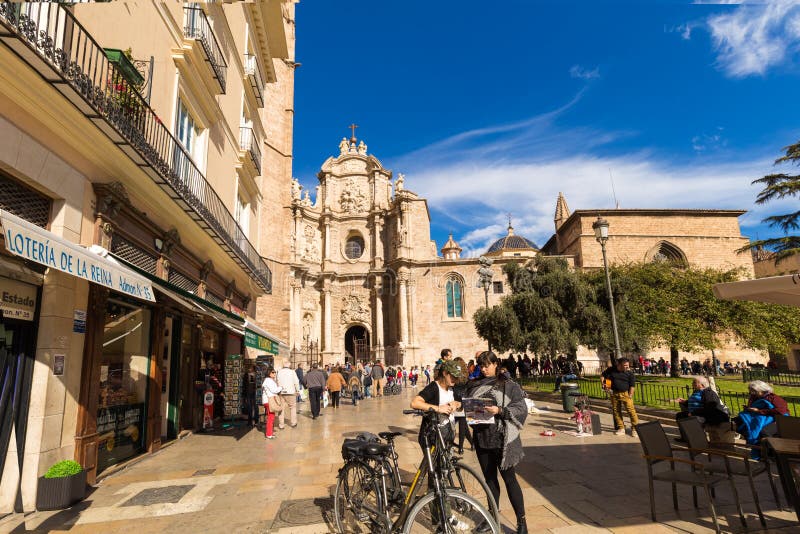 VALENCIA, SPANJE - november 15, 2017: De jonge meisjes op fietsen bestuderen een kaart over Kathedraalbasiliek stock foto's VALENCIA, SPANJE - november 15, 2017: De jonge meisjes op fietsen bestuderen een kaart over Kathedraalbasiliek stock foto's