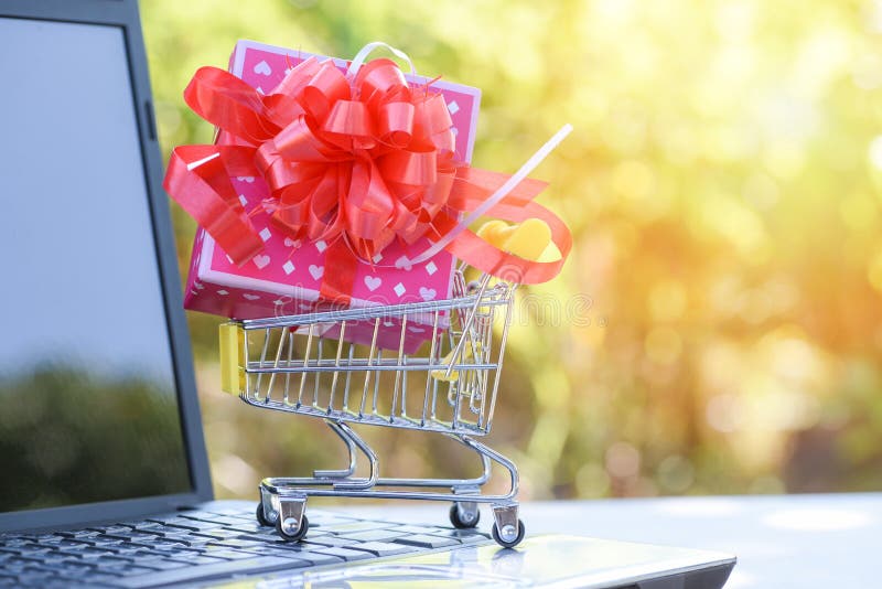 Valentijnskaartendag het winkelen en de Roze huidige doos van de Giftdoos met rode lintboog op boodschappenwagentje die online wi royalty-vrije stock foto's Valentijnskaartendag het winkelen en de Roze huidige doos van de Giftdoos met rode lintboog op boodschappenwagentje die online wi royalty-vrije stock foto's