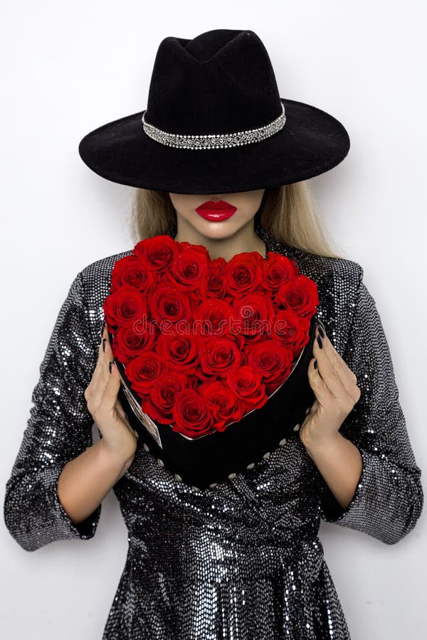 Valentine Beauty flicka med röda hjärtarosor Stående av en ung kvinnlig modell med gåvan och hatten som isoleras på bakgrund royaltyfria bilder Valentine Beauty flicka med röda hjärtarosor Stående av en ung kvinnlig modell med gåvan och hatten som isoleras på bakgrund royaltyfria bilder