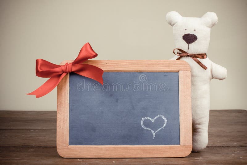 Valentine card with Teddy bear, heart on wooden black board with bow in vintage style