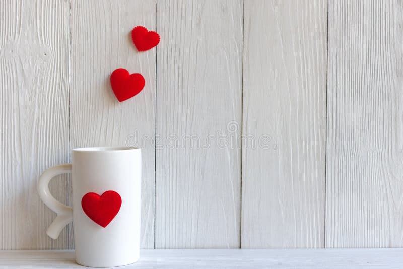 Valentine Day met rode kopkoffie naaide de rijgrens van hoofdkussenharten, houten witte achtergrond royalty-vrije stock fotografie Valentine Day met rode kopkoffie naaide de rijgrens van hoofdkussenharten, houten witte achtergrond royalty-vrije stock fotografie
