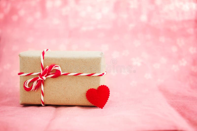 Valentine gift box concept with red heart on sweet pink fabric b