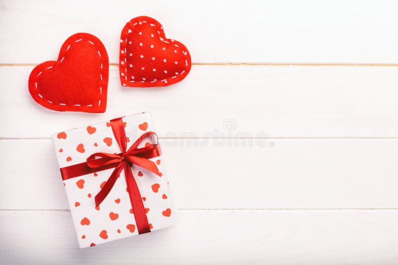 Valentine or other holiday handmade present in paper with red hearts and gifts box in holiday wrapper. Present box gift on white