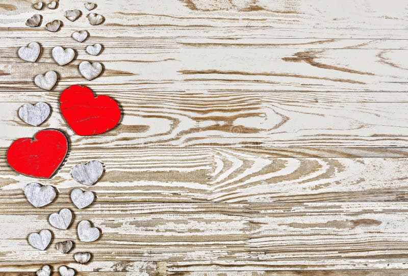 Valentine`s day background. Homemade hearts made of wood on a wooden background. Heart is a symbol of love . top view