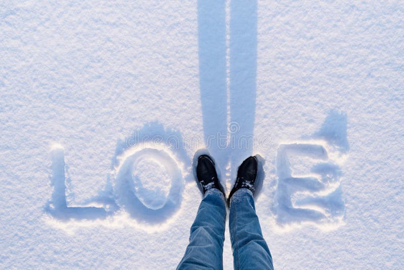 Valentine`s Day card with the word love in the snow