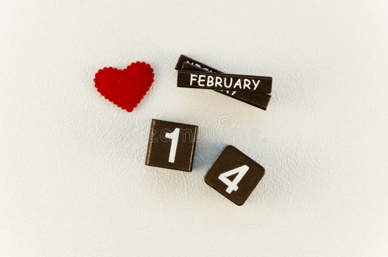 Valentine`s day concept. 14 February wooden block calendar and pillow red felt heart on a white table. Top view royalty free stock photos Valentine`s day concept. 14 February wooden block calendar and pillow red felt heart on a white table. Top view royalty free stock photos