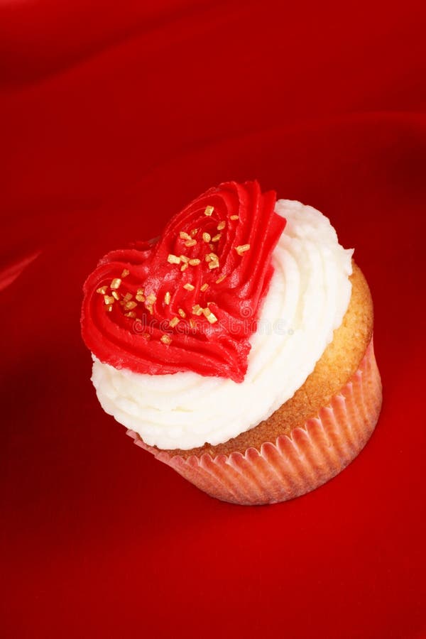 Fancy Valentine's day cupcake frosted with a red heart shape over a red background. With copyspace. Day copyspace stock images, royalty-free photos and pictures