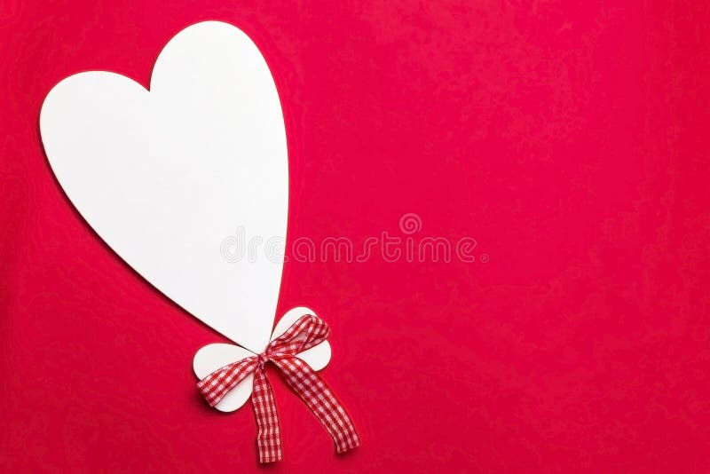 Valentine`s day holiday, mother`s day, March 8, wedding invitation. Symbol of love white wooden heart on a red background with royalty free stock photo Valentine`s day holiday, mother`s day, March 8, wedding invitation. Symbol of love white wooden heart on a red background with royalty free stock photo