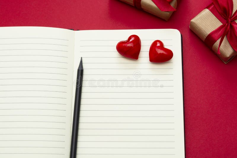 Valentine&#x27;s Day mock up. Open notebook with red hearts and gift boxes, on red background, copy space for text stock images