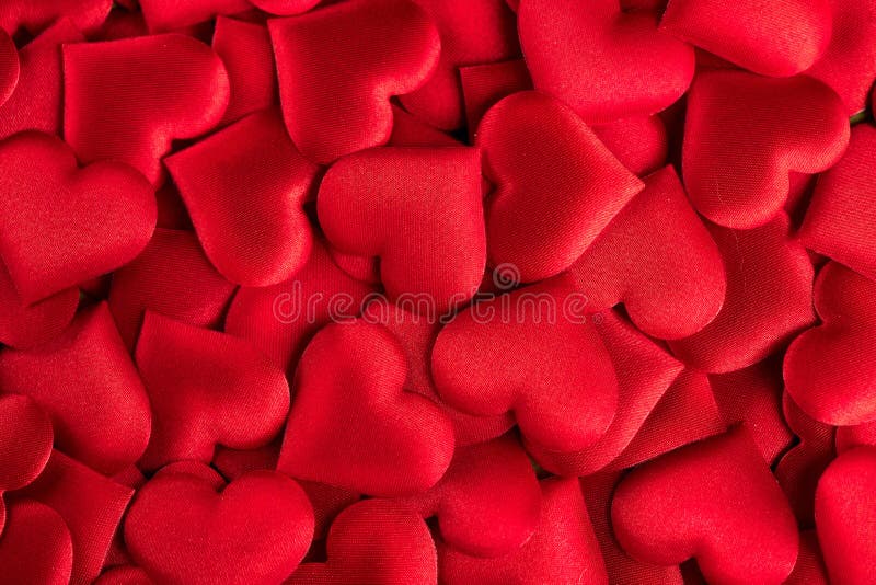 Valentine`s Day. Red heart shape backdrop. Abstract holiday Valentine background with red satin hearts. Love concept