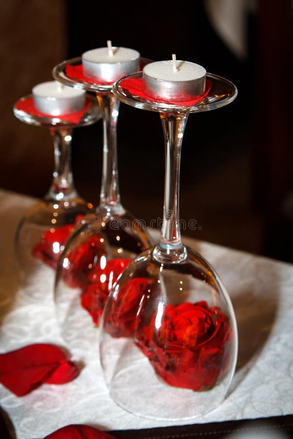 Valentines day restaurant decoration three wineglasses with candles and red roses on the table. Valentines day restaurant decoration three wineglasses with candles and red roses on the table