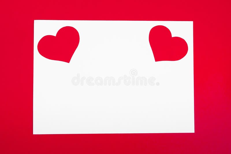 Valentine`s Day. Two red hearts on a white empty paper sheet. Paper card on red background. Copy space. Valentine`s Day. Two red hearts on a white empty paper sheet. Paper card on red background. Copy space.