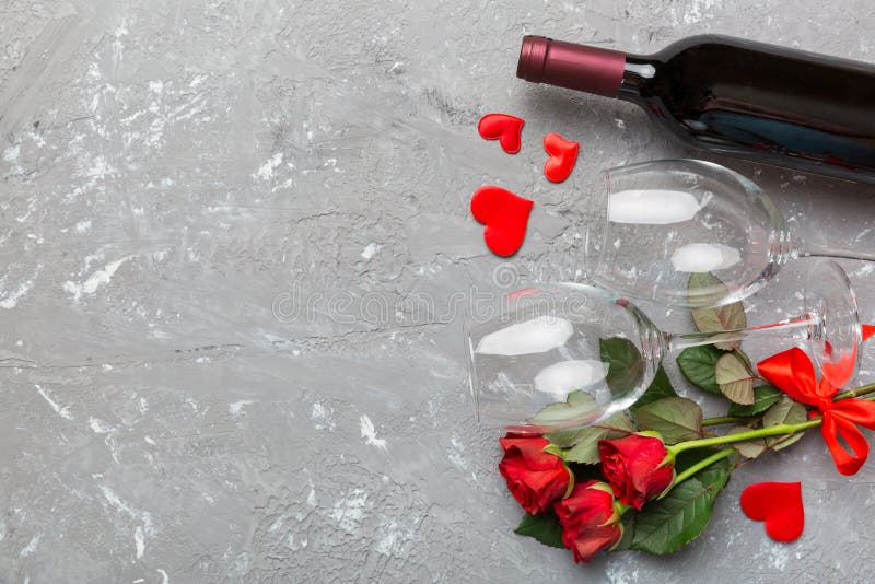 Valentine&x27;s day composition with red wine, rose flower and gift box on table. Top view, flat lay. Holiday concept