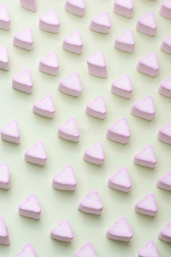 Valentines Day candy hearts marshmallows over green background