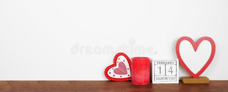 Valentines Day heart decor, candle and rustic calendar on a shelf